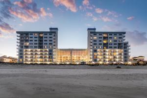 two tall buildings on the beach at dusk at Princess Royale Oceanfront Resort in Ocean City