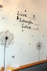 a wall with dandelions and words live laugh love at Casa Linda Victoriaville in Princeville