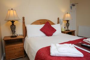 1 dormitorio con 1 cama grande con 2 lámparas y toallas en The Seacliffe - Whitby en Whitby