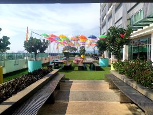 a patio with tables and umbrellas on a building at A's House i-City 1-4pax Studio Netflix Wifi in Shah Alam