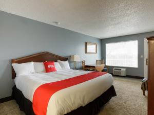 een slaapkamer met een groot bed en een rode deken bij OYO Hotel Branson MO-165 in Branson