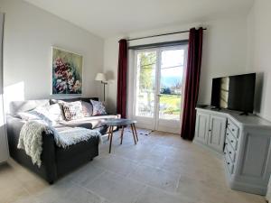 a living room with a couch and a tv at Le Moulin de Felix in Robion en Luberon