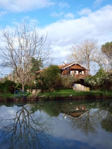 Meilhan-sur-GaronneにあるGîte Au Jardinの湖畔に腰掛けた家