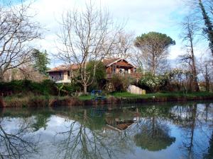 a house on the side of a river at Gîte Au Jardin in Meilhan-sur-Garonne