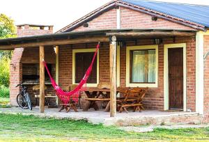 ein Backsteinhaus mit einem Picknicktisch und roten Hängematten in der Unterkunft La Maína Cabañas in San Javier