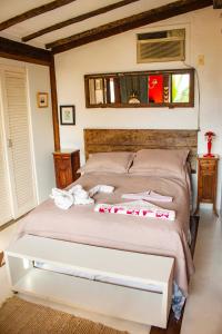 a bedroom with a bed with towels on it at Suites de Charme Feiticeira in Ilhabela