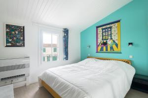 ein Schlafzimmer mit einem Bett und einem Wandgemälde in der Unterkunft Maison Amande in La Flotte