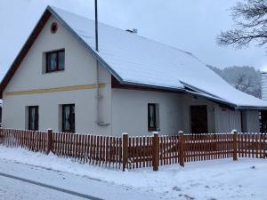 Nezdice na Šumavě 103 في Nezdice: بيت ابيض فيه سياج في الثلج