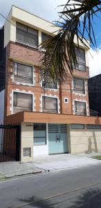 a tall brick building with two garage doors on a street at 100 Wonderful House in Bogotá