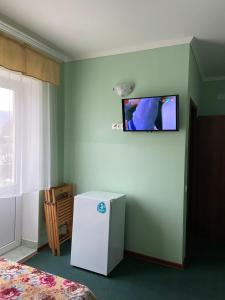 アゴイにあるЖилой домの冷蔵庫、壁掛けテレビが備わる客室です。