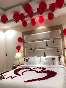 a bed with red balloons hanging from the ceiling at Rohara Resort in Taif