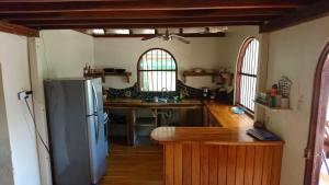 a kitchen with a refrigerator and a wooden floor at Casa Verde, Cahuita in Cahuita