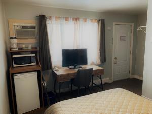 a bedroom with a desk with a computer and a bed at Hawberry Motel in Little Current