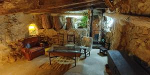 a living room with a couch and a table in a stone wall at El Refugio de Su - Casa Rural in Auñón