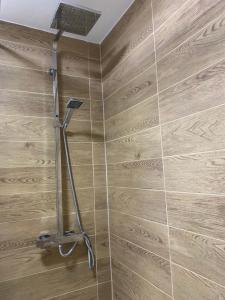 eine Dusche im Bad mit einer Holzwand in der Unterkunft Room in Central London Overview Thames in London
