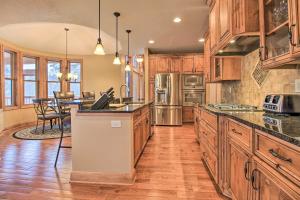 a large kitchen with wooden cabinets and a dining room at Lakefront Giants Ridge Retreat Near Ski and Golf! in Biwabik