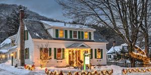 a house decorated with christmas lights in the snow at The Woodstocker B&B in Woodstock