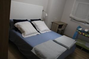 a bedroom with a bed with blue and white sheets and pillows at Rosalía de Castro, 41 - Centro - VUT-CO-01904 in Santiago de Compostela