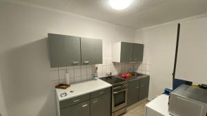a small kitchen with gray cabinets and a sink at Ferienhaus Bungalow in Arendsee in ruhiger Lage in Arendsee