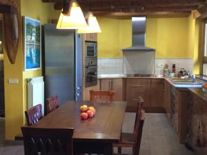 una cocina con una mesa de madera con fruta. en Casa Carbonero, en Lascuarre
