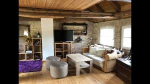 ein Wohnzimmer mit einem Sofa und einem TV in der Unterkunft Ferienhaus in Arendsee mit direkter Seenähe in Arendsee