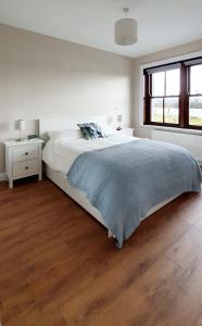 1 dormitorio blanco con 1 cama y suelo de madera en Riverside Marina Apartments, en Lanesborough