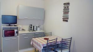 a small kitchen with a table and a tv at Les Milles Gouttes Résidence La Feuillée in Le Mont-Dore