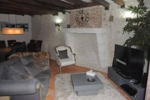 a living room with a couch and a tv at MAISON DE CARACTERE COSY in Sambin