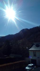 Eine Sonne, die über einem Haus leuchtet in der Unterkunft Les Milles Gouttes Résidence La Feuillée in Le Mont-Dore