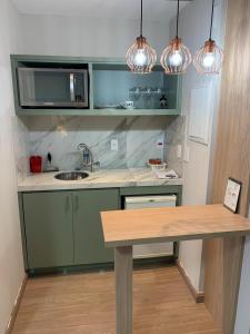 a kitchen with a table and a microwave at Jardim Paulista Apartamento com Vista in Sao Paulo