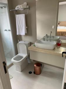a bathroom with a sink and a toilet and a mirror at Jardim Paulista Apartamento com Vista in Sao Paulo