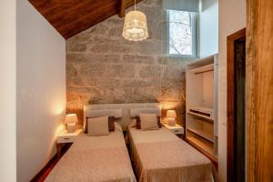 沃澤拉的住宿－Quinta das Lamas - Oak Tree House，一间卧室设有两张床和砖墙