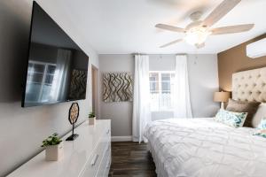 a bedroom with a white bed and a ceiling fan at Long Beach Duplex King Bed Pet Friendly Nurses Surgeon Business Travelers Near St Marys Medical Center & Downtown in Long Beach