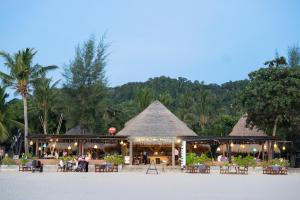 un complejo en la playa con mesas y sillas en Southern Lanta Resort - SHA Extra Plus, en Ko Lanta