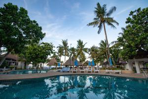 a pool at a resort with chairs and palm trees at Southern Lanta Resort in Ko Lanta