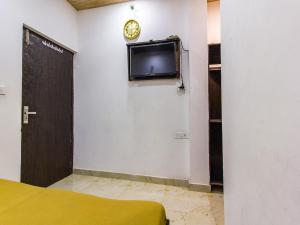 a room with a tv on the wall and a door at Sharma's BNB in Amritsar