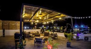 an outdoor patio at night with furniture and lights at Hotel Casa Maldonado in Ica