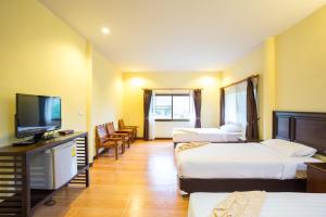 a hotel room with three beds and a flat screen tv at Star Hill River Kwai Resort in Ban Kaeng Raboet