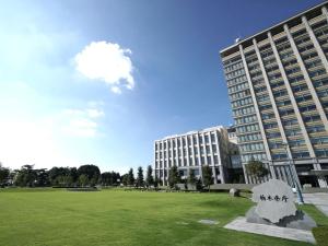 a large building with a statue in the middle of a field at Hotel The Centre Utsunomiya in Utsunomiya