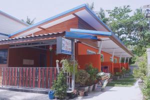 een oranje gebouw met een luifel en planten buiten bij PK Family House in Ko Mook