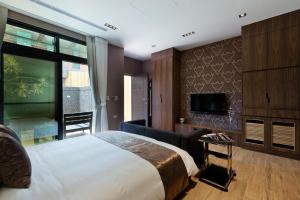 a bedroom with a large bed and a flat screen tv at Skyline B&B in Yuanshan
