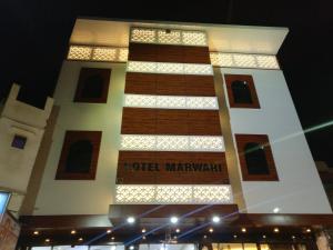 um edifício alto com um cartaz à noite em Hotel Marwari em Agra