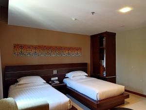 Postel nebo postele na pokoji v ubytování Kinabalu Daya Hotel