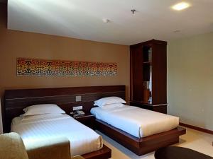 Postel nebo postele na pokoji v ubytování Kinabalu Daya Hotel