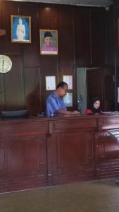 a man standing at a counter in a room at Motel Desa in Kuala Terengganu