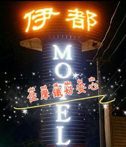a neon sign with chinese writing on the side of a building at 伊都旅店 Motel in Dacun