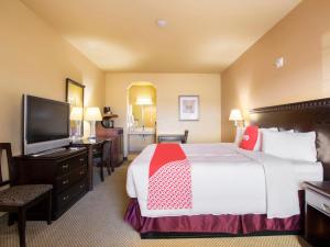 a hotel room with a bed and a flat screen tv at OYO Hotel Valley View TX, I-35 in Valley View