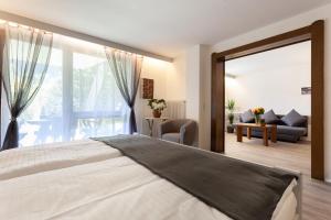 a bedroom with a large bed and a living room at Hotel Petra in Baiersbronn