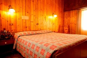 a bedroom with a bed in a wooden wall at Hotel Ristoro Vagneur in Saint Nicolas +20 photos