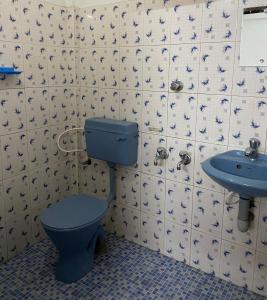 a bathroom with a blue toilet and a sink at Shiva Inn in Guruvāyūr